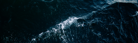Aerial view of dark, choppy ocean waves with white foam