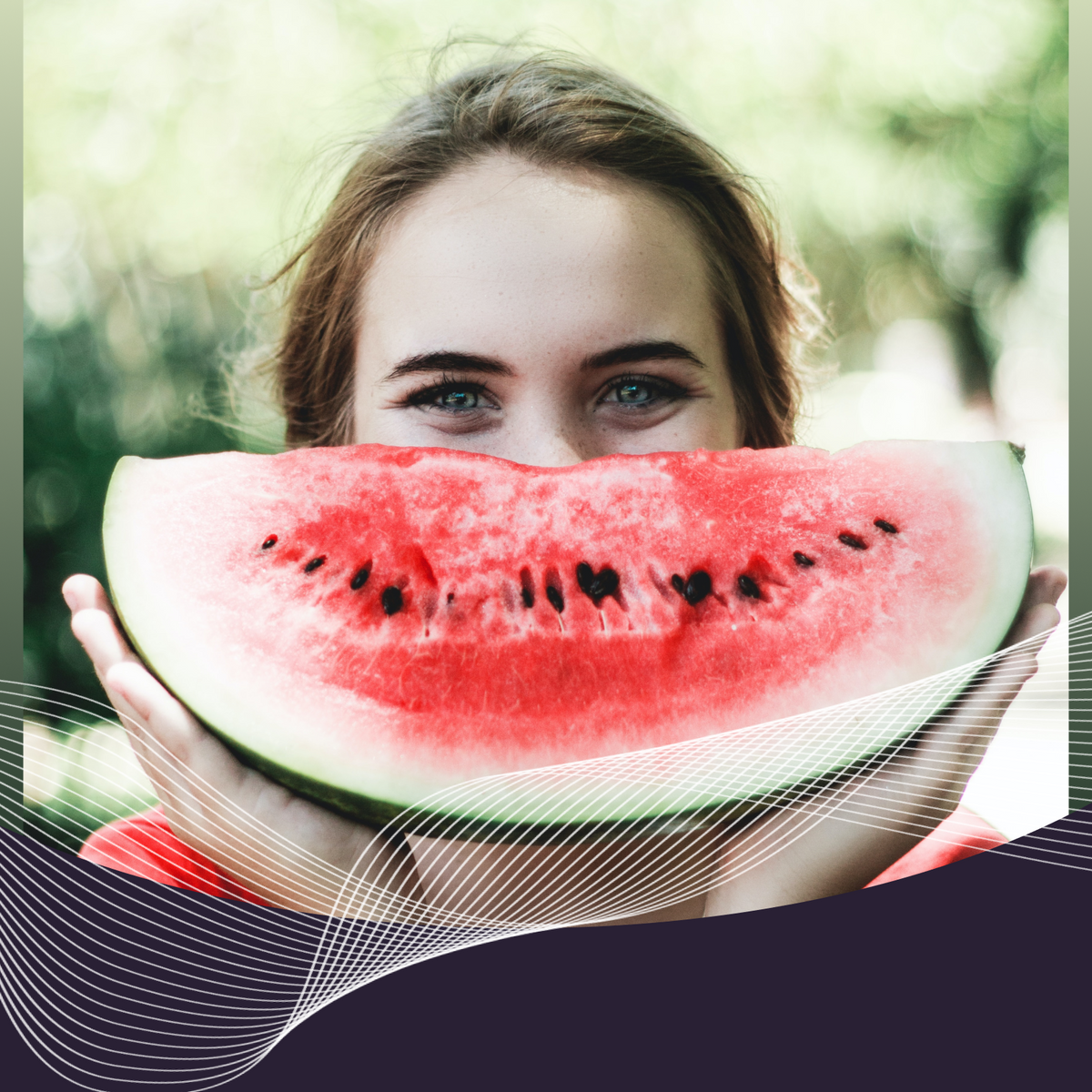 Young woman peeking over a large watermelon slice outdoors with blurred green background
